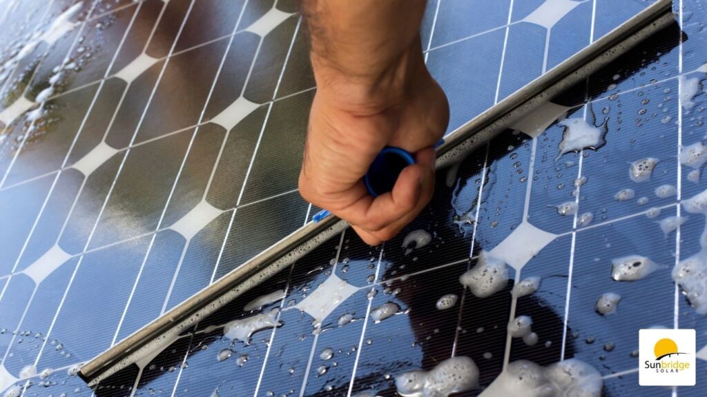 a professional cleaning a solar panel with a brush