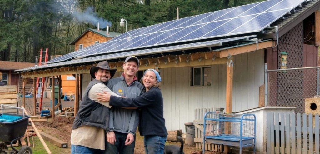 happy washington solar customers hugging the founder of sunbridge jordan weisman