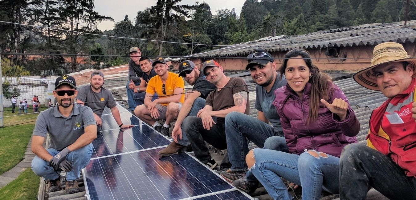 sunbridge team celebrating a completed humanitarian solar project