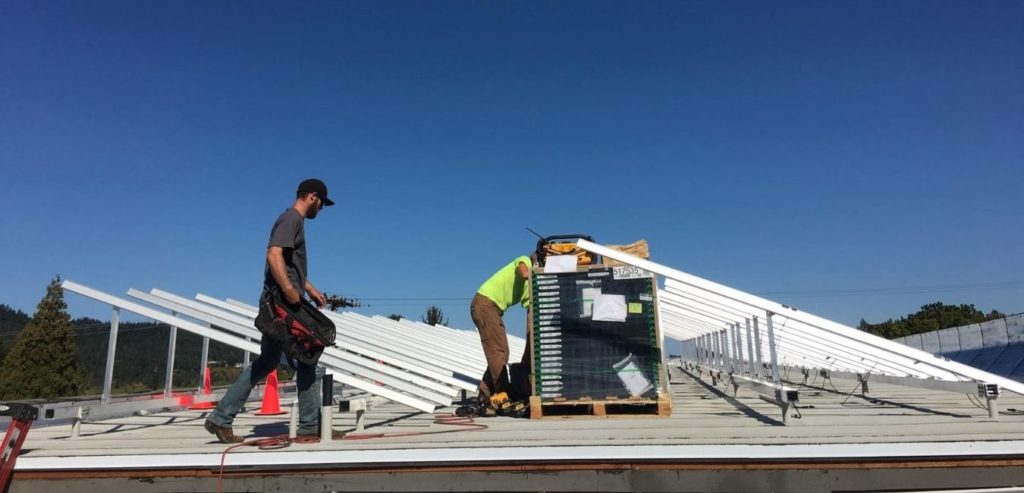 two local solar installers on a roof