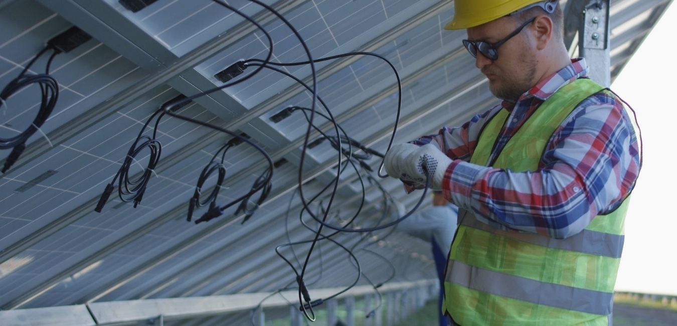 Workers connecting wires of solar panels