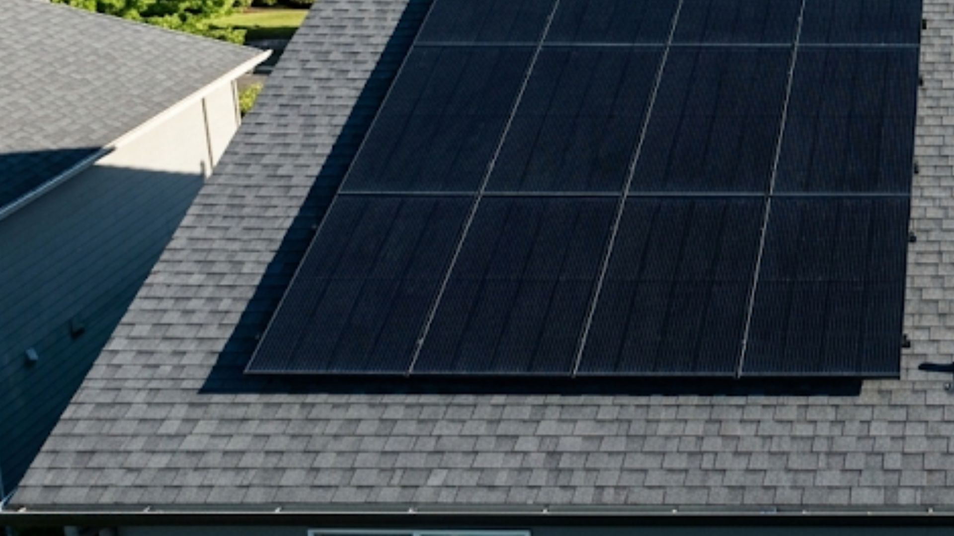 A row of dark solar panels installed on a gray shingled roof using the 36 inch rule